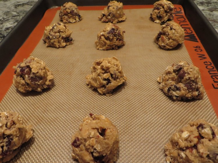 chocolate-pecan oatmeal cookies with dried cherries, dough portioned onto baking sheet