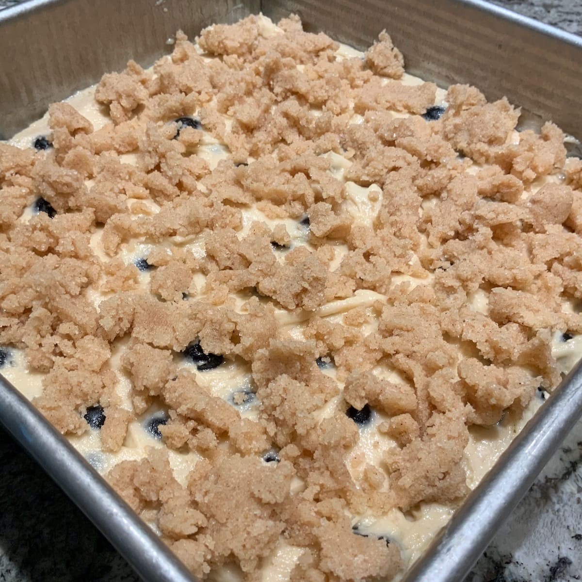 Crumb topping placed on Blueberry Crumb Cake